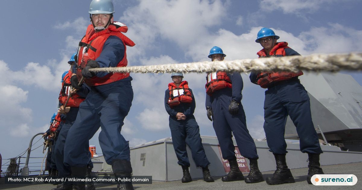 U.S. Navy Electronics Technician 2nd Class Timothy Miller, foreground left, assigned to the guided missile destroyer USS Mason (DDG 87), heaves in a line